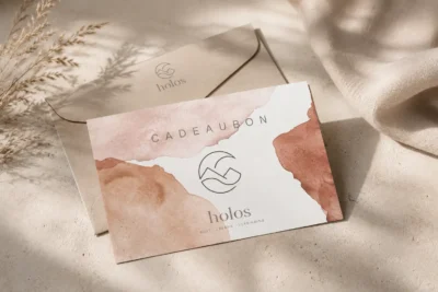 Holos cadeaubon met envelop, in oudroze en terracotta aquarel, met het Holos-merkteken