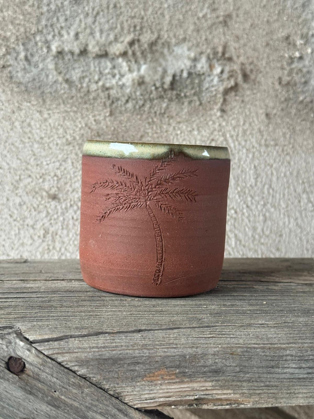 Beker uit rode klei met een ingekerfde palmboom en een beige geglazuurde rand